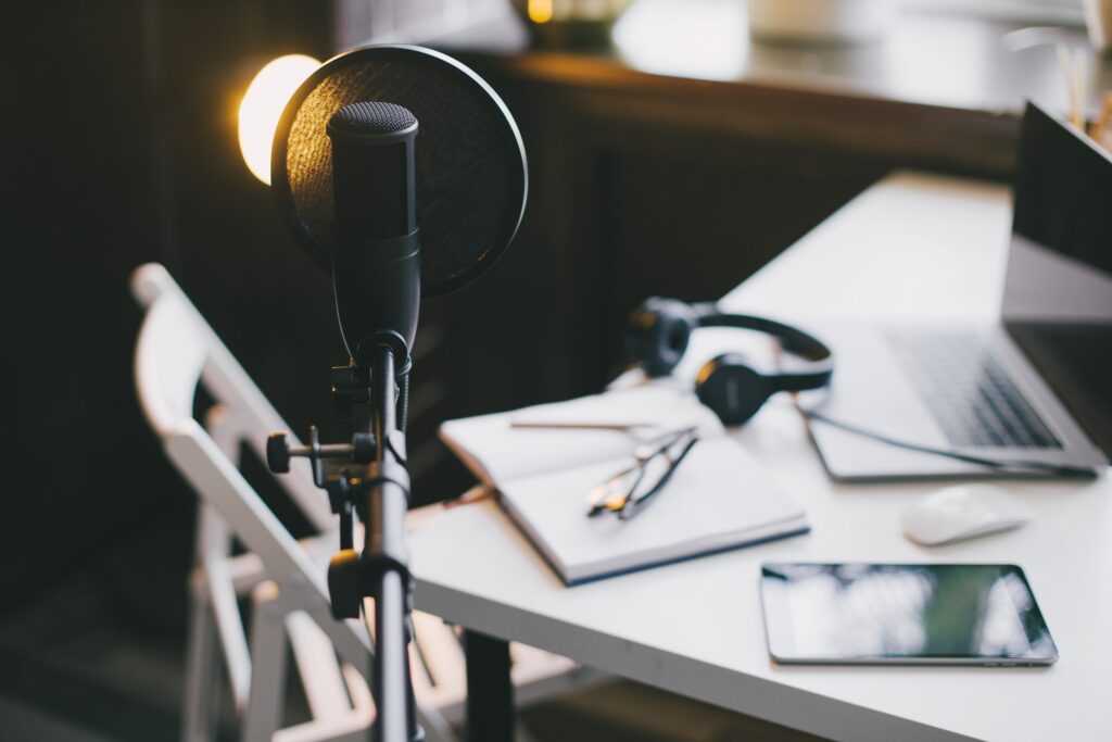 Professional equipment for recording podcast: microphone, earphones and laptop in a studio.
