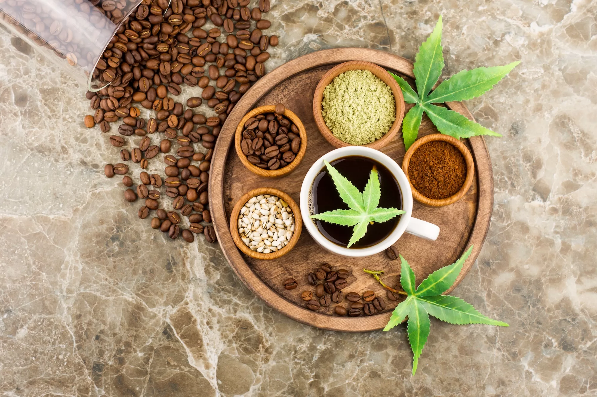 coffee beans, a cup of freshly brewed coffee with cannabis, morijuana seeds and leaves on a tray.